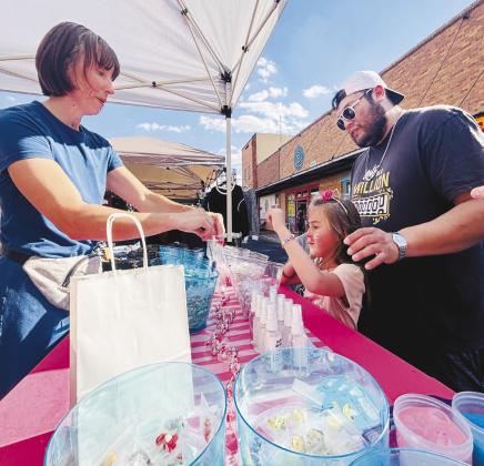 A young girl picks out slime from Ava’s Slime Bar, a Lubbock-based business selling handcrafted slime, during Stanton Trade Days over the weekend.