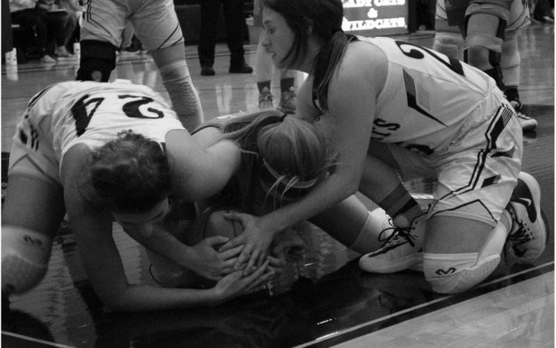 Grady’s Haydn Burge and Ashely Hill battle a Borden County Coyote for a loose ball during district action Tuesday night in Grady.