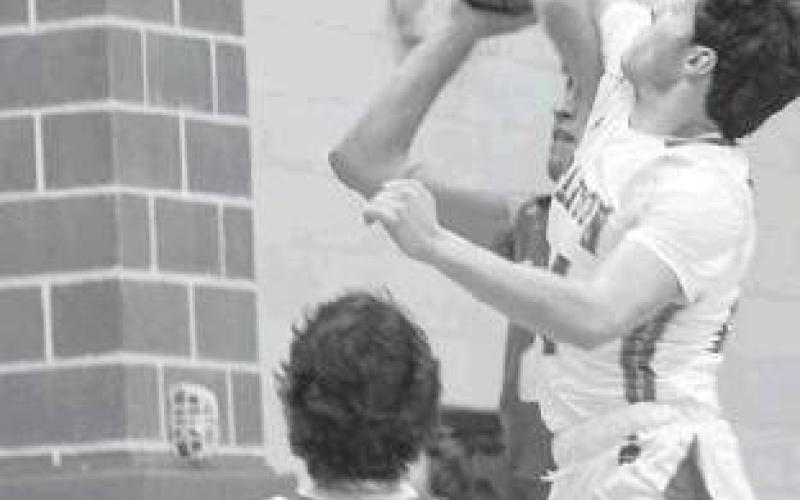Jaxson Lindell guards the basket with a fierce block on a Coahoma Bulldog during district action in Stanton.