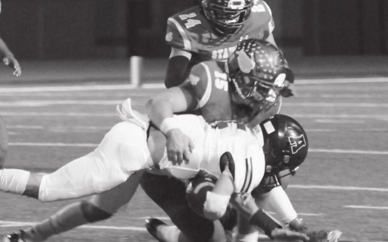 Tyler Benedict (15) and Eddie Wittenbarger (24) bring down an Abernathy Antelope during district action last week in Stanton.