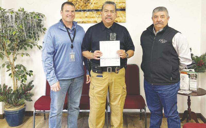 Pioneer Natural Resources donated ten thousand dollars to the Stanton Police Department. Robert Guillot and Jorge Hinojosa, both with the Pioneer Security Department are shown here presenting the check to Chief of Police, J.B. Morales. The money will go to obtaining equipment for the Police Department.