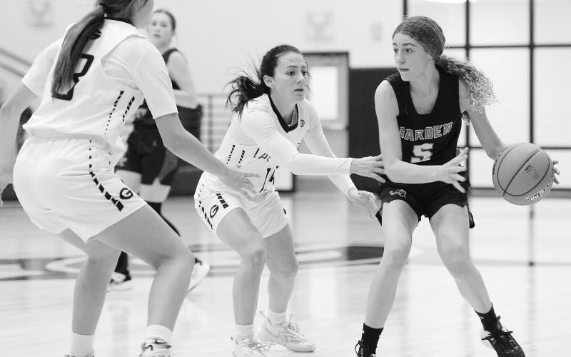 Garden City guard Emy Schwartz (5) looks to pass the ball during non-district action against Grady earlier this season. Defending for Grady are Jessi Everett and Emma Parker.