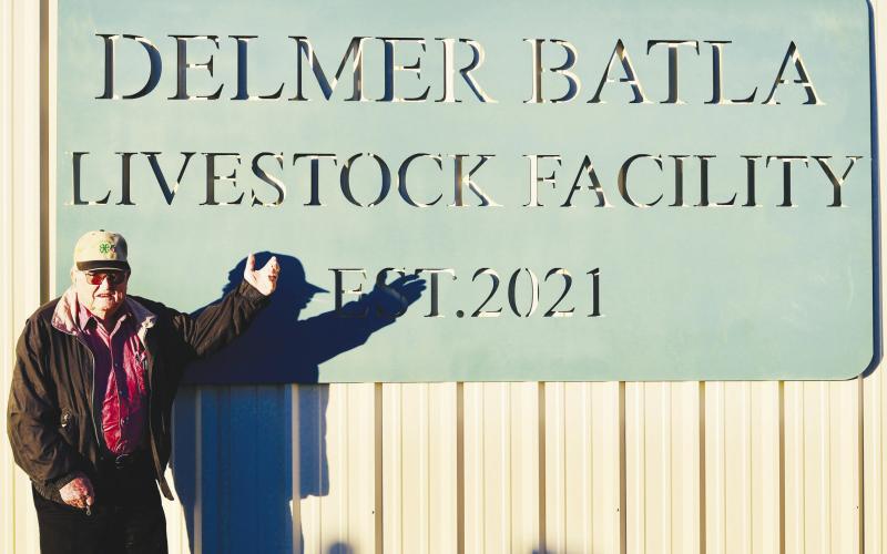Delmer Batla, 91, stands proudly beside the newly unveiled sign naming the Glasscock County livestock facility in his honor.