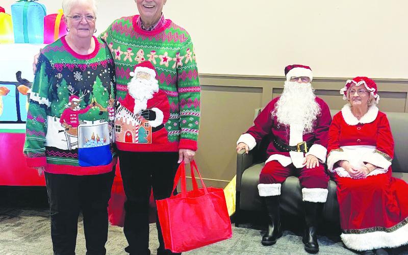 Danny and Billie Fryar pose next to Santa and Mrs. Claus at the senior center Christmas party. Each guest received a bag of gifts purchased with funds raised by The Corner Day Spa &amp;amp; Salon.