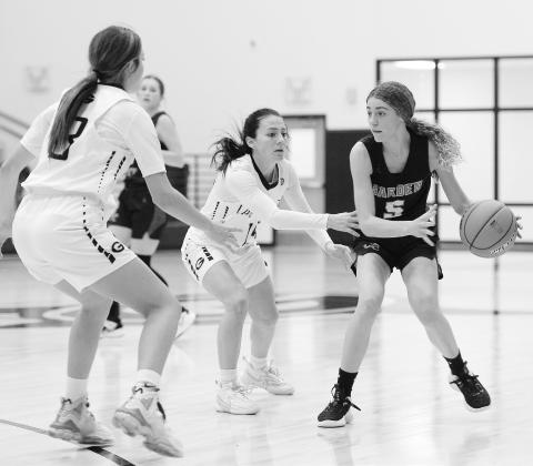 Garden City guard Emy Schwartz (5) looks to pass the ball during non-district action against Grady earlier this season. Defending for Grady are Jessi Everett and Emma Parker.