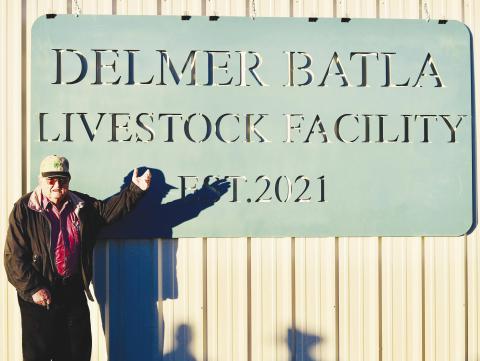 Delmer Batla, 91, stands proudly beside the newly unveiled sign naming the Glasscock County livestock facility in his honor.