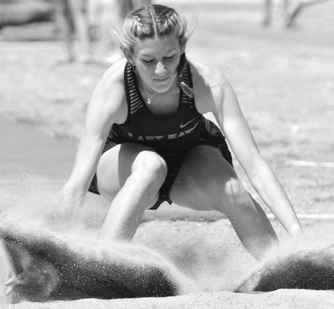 Barbara Wittrein splashes down in the sand after recording her district champion leap in the long jump. Wittrein will compete in five events, the most possible, at the Area 7&amp;8 Meet.