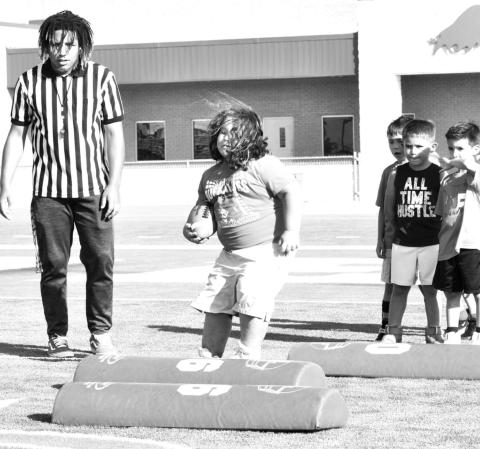 Coaches from the Norman Elite Football Camp taught the young players how to secure the football while working on lateral movements.