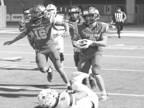 Stanton’s Tyler Waggoner returns a blocked extra point while Aiden Hinojosa clears a path during district action against Littlefield last Friday in Stanton.
