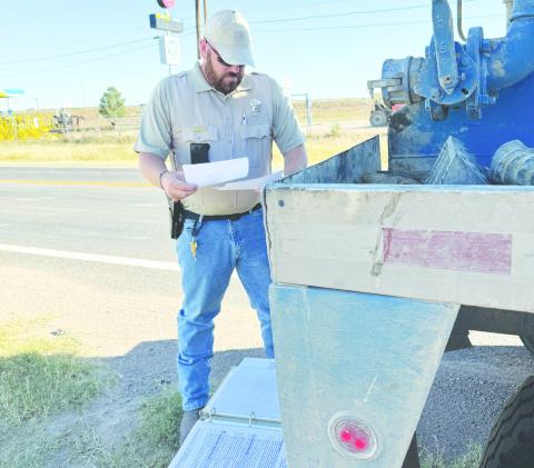 Martin County deputy Chase Stiles looks over some environmental standards during a traffic stop in Martin County. Stiles is looking to make an impact cleaning up the county