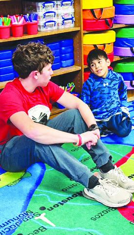 A Garden City High School senior chats with a second grader as the two get to know each other through the new Bearkat Buddies program.