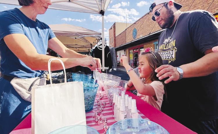 A young girl picks out slime from Ava’s Slime Bar, a Lubbock-based business selling handcrafted slime, during Stanton Trade Days over the weekend.